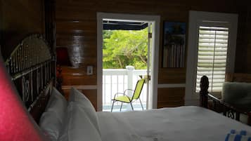 Una habitación con cama, una silla y vistas a la vegetación.