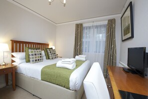 Relax in comfort with a large bed, flat-screen TV, and workspace.