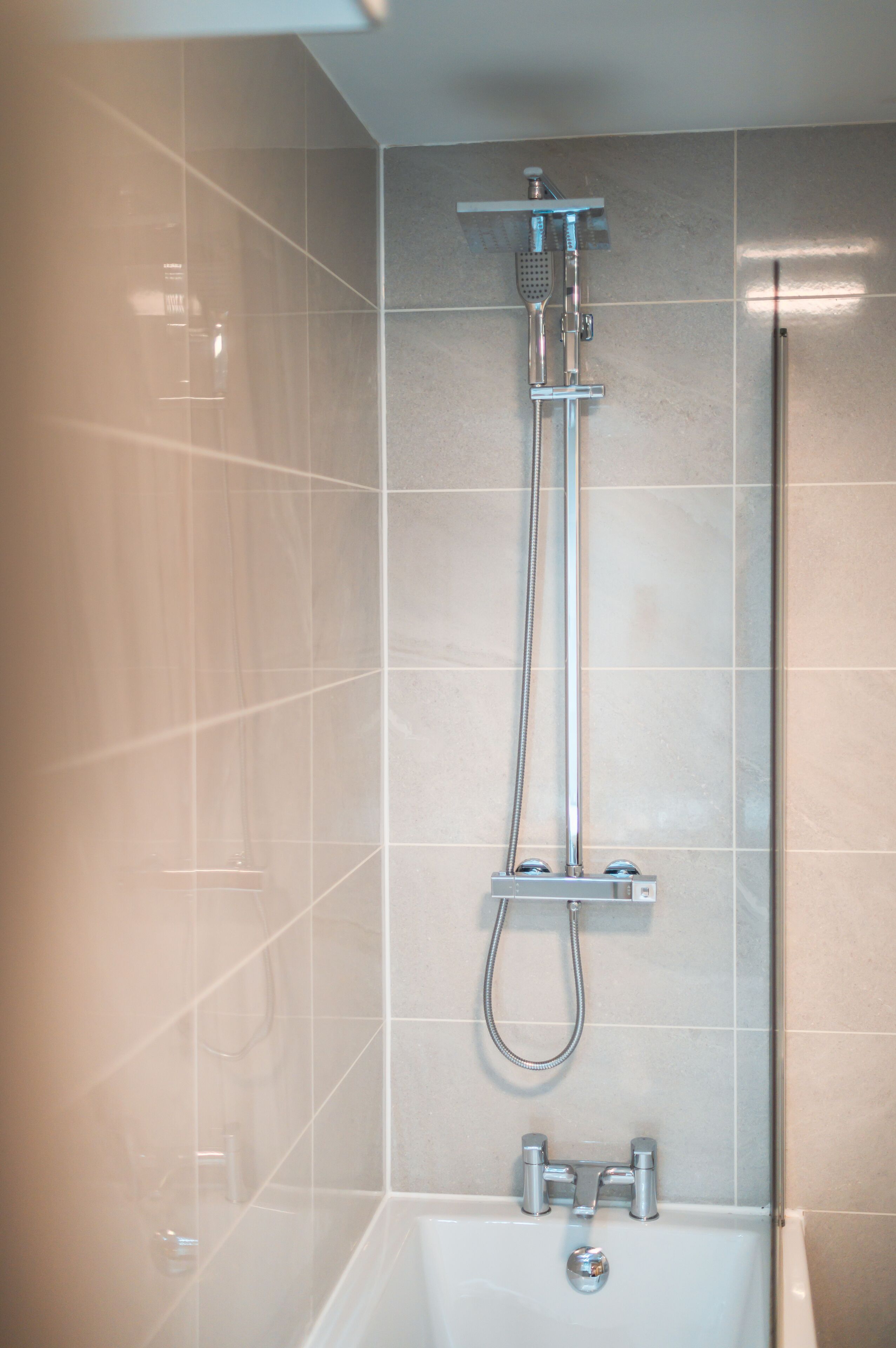 Un baño moderno con ducha de vidrio, bañera y retrete.