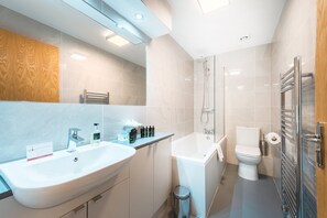 Enjoy a refreshing bath in the spacious bathtub with a handheld showerhead.