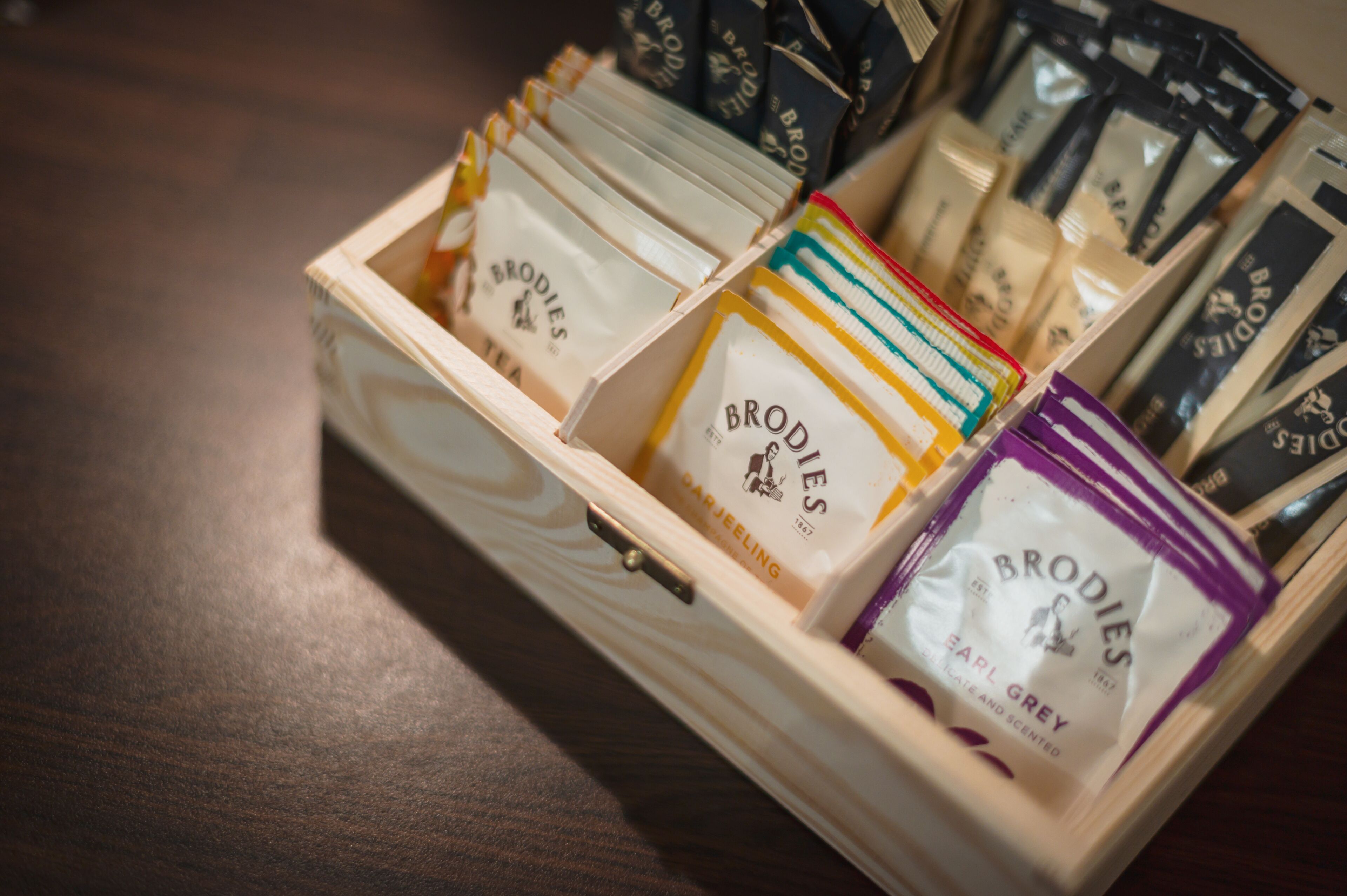 A wooden box containing various scented products labeled 'Brodies'.