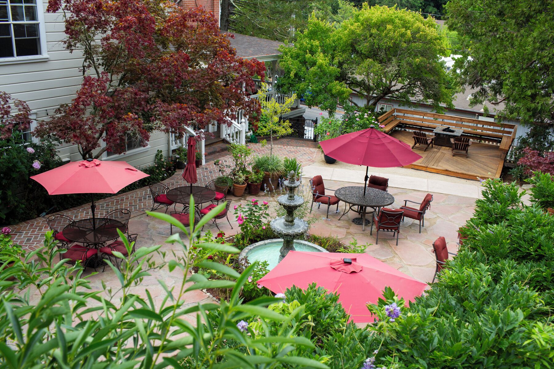 A patio area with outdoor seating, a fountain, and potted plants.