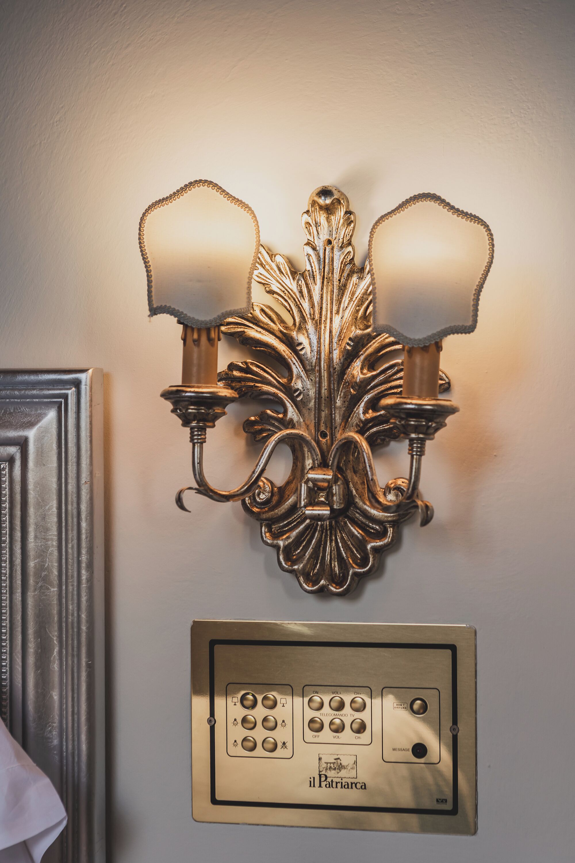 Un luminaire mural doté de deux lampes et d’un panneau de commande situé en dessous.