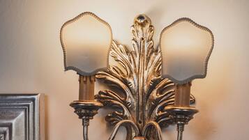 Un luminaire mural doté de deux lampes et d’un panneau de commande situé en dessous.