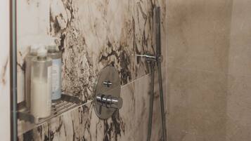 Ducha con cabezal de ducha de mano y grifo empotrado.