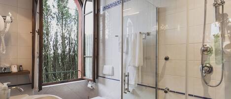 A bathroom with a glass-enclosed shower, a toilet, a bidet, and a sink.