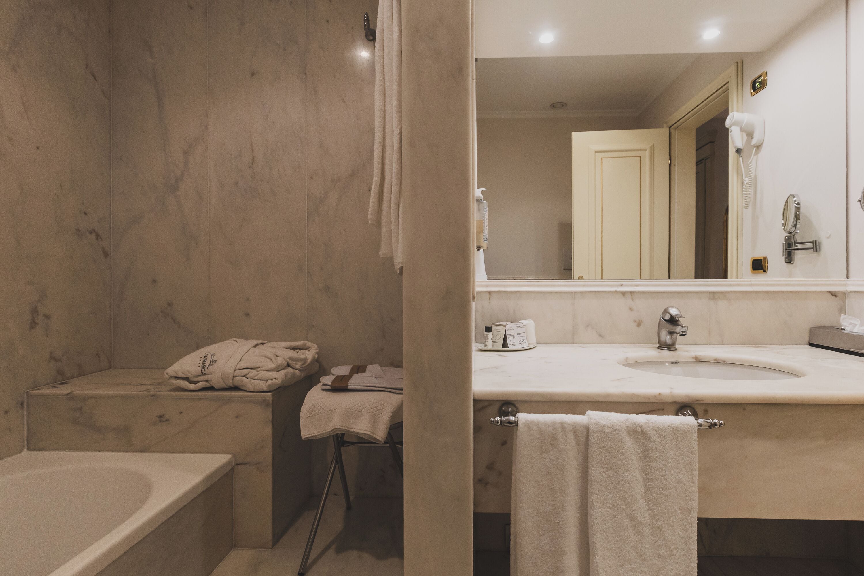Une salle de bain avec une baignoire, un lavabo, un miroir et des serviettes.