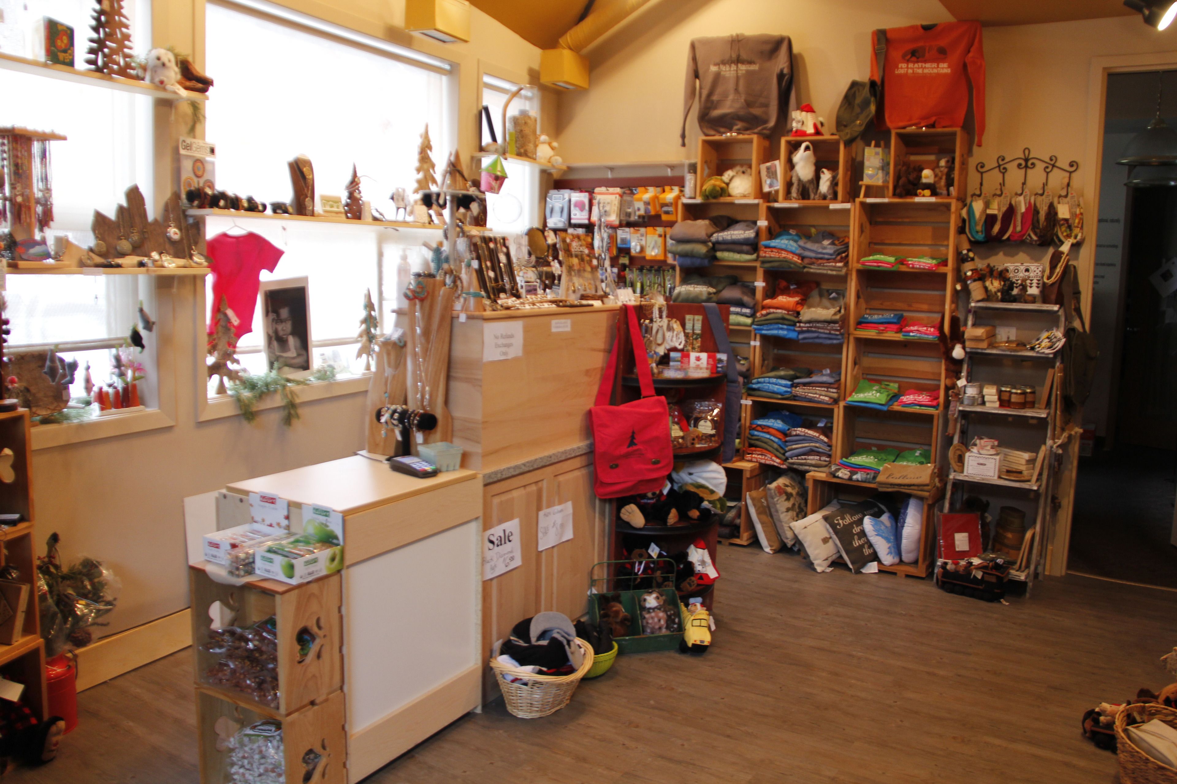 Une petite boutique avec des étagères en bois où sont exposés divers articles, comme des sacs, des chapeaux et des accessoires.