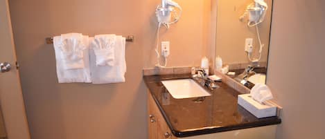 A bathroom with a sink, two towel racks, a mirror, and a toilet.