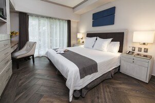 Une chambre d’hôtel moderne, dotée d’un grand lit, d’un bureau et d’une chaise.