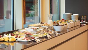 A buffet setup with various food items and utensils. - Hotel Hoffmeister (Prague)