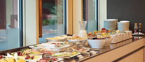 A buffet setup with various food items and utensils.
