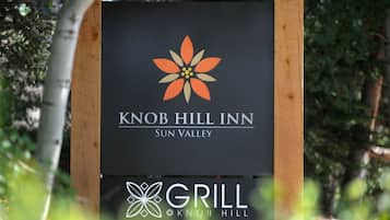 Une enseigne pour le Knob Hill Inn à Sun Valley, avec un logo et une mention indiquant la présence d’un restaurant-grill.