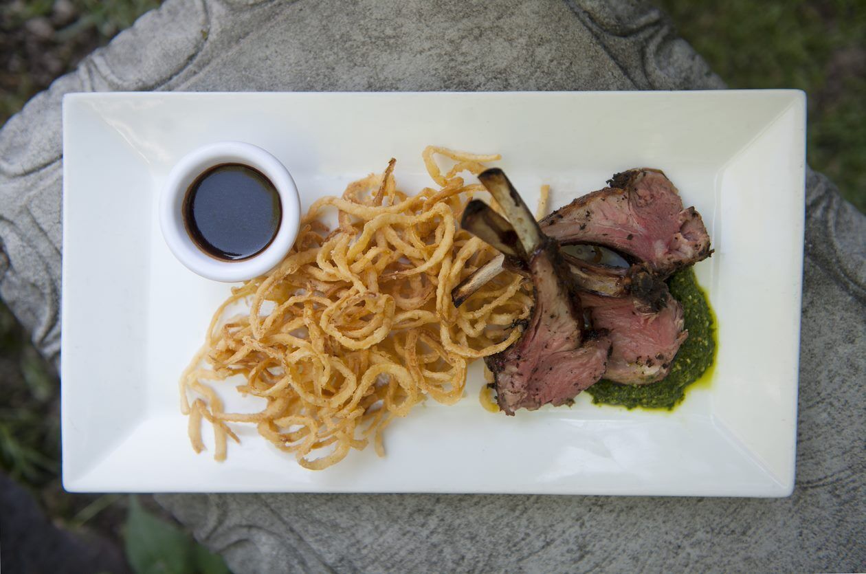 Ein Teller mit aufgeschnittenem Fleisch, Zwiebelringen und einer kleinen Soßenportion.