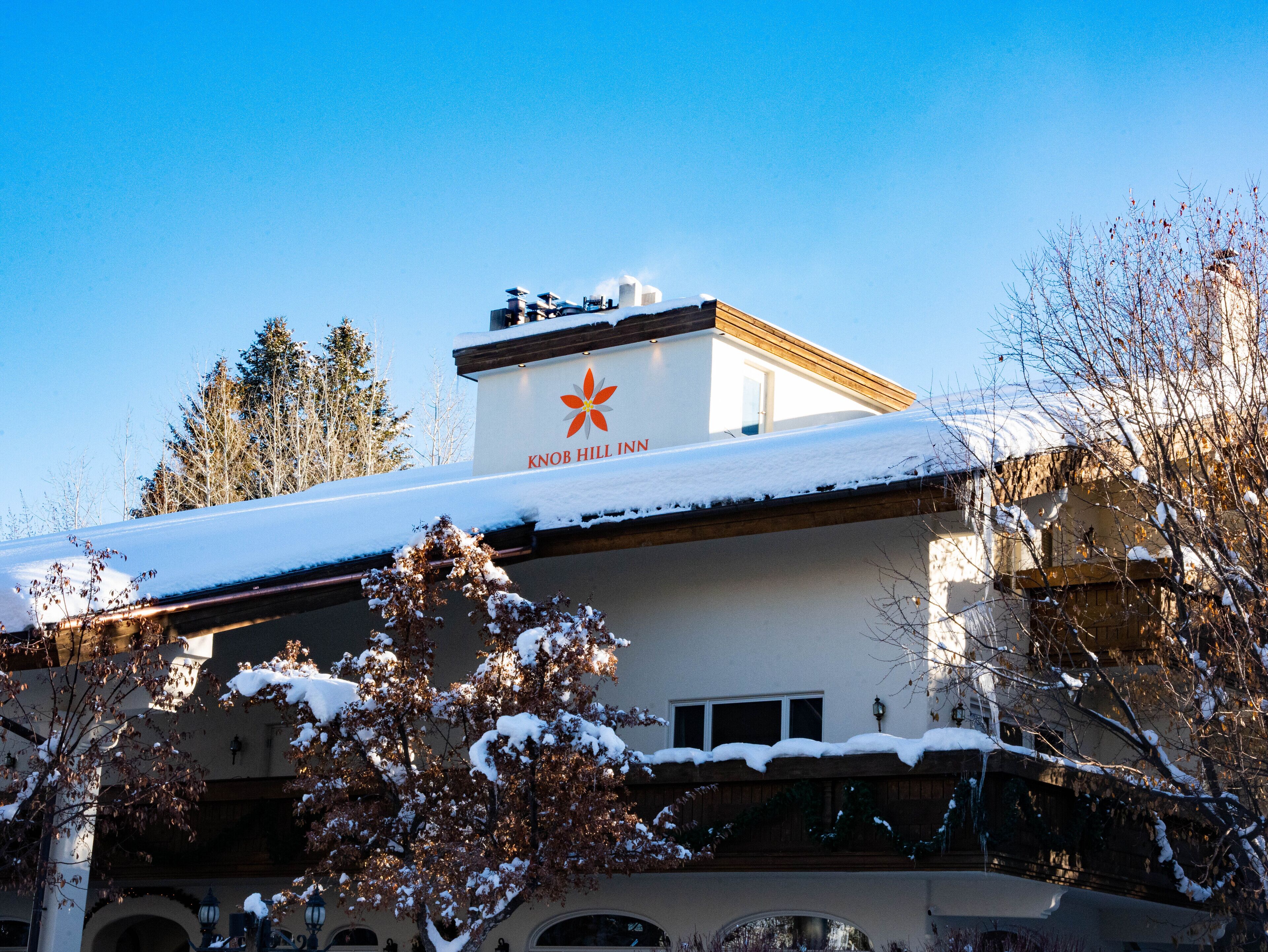 Un hôtel dont le toit est recouvert de neige et sur lequel on peut lire l’inscription « Knob Hill Inn ».