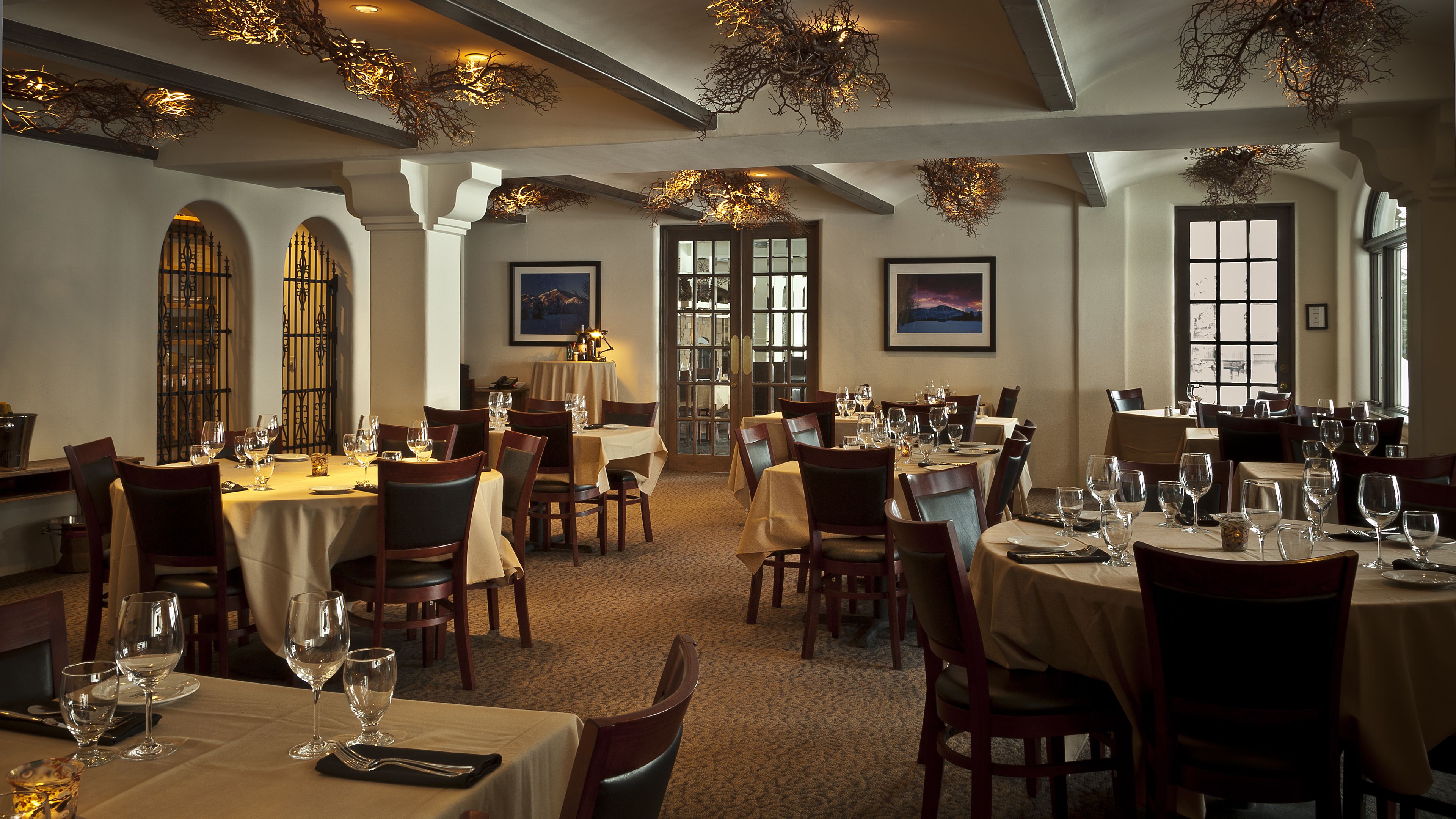 Un restaurant doté de nombreuses tables, de chaises et de luminaires suspendus.