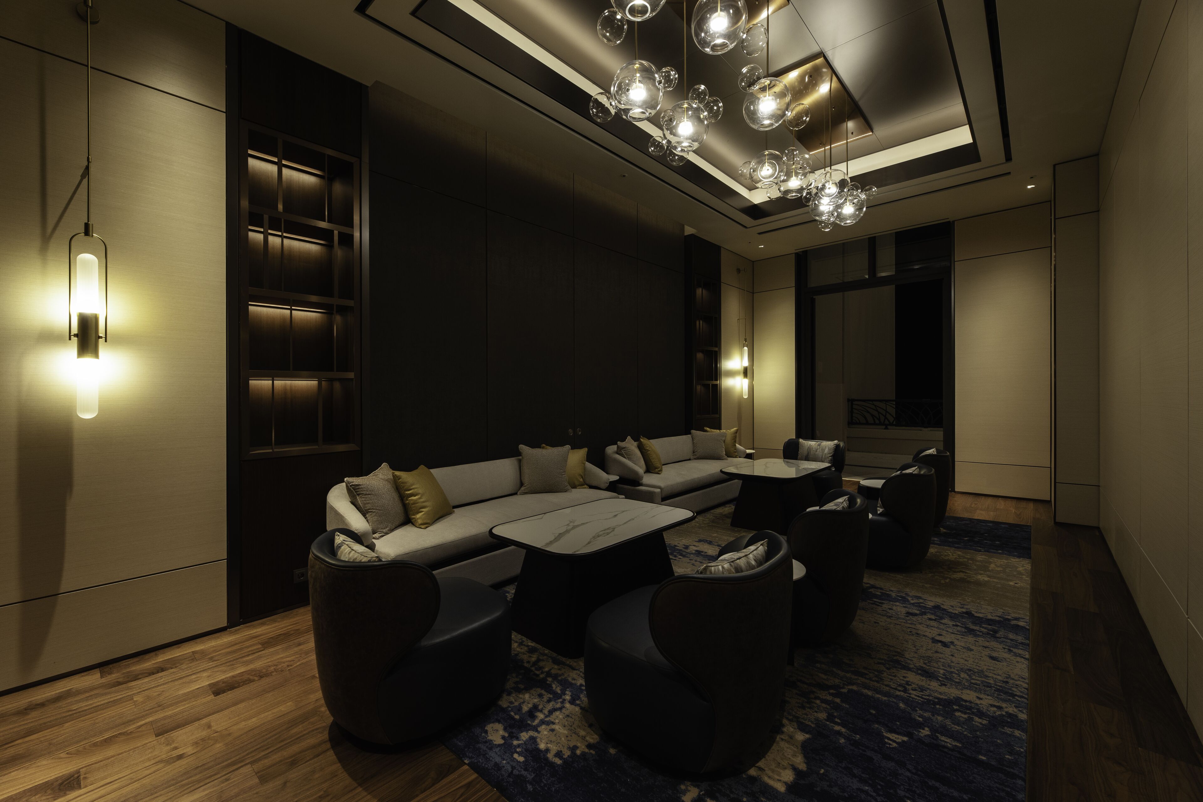 A modern living room with a sectional sofa, round coffee tables, and a patterned rug.