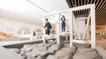 A children's play area with a soft, cushioned floor and a climbing structure.