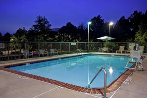 Una piscina al aire libre de temporada, sombrillas