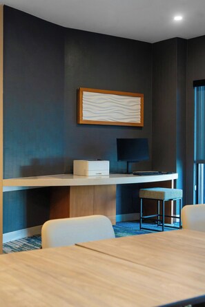A modern hotel room with a curved desk, a flat-screen TV, a cushioned stool, and a large window. - SpringHill Suites by Marriott Atlanta Kennesaw (Kennesaw)