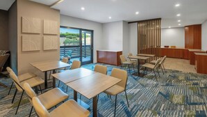 A hotel room with a large window, a desk, a chair, a bed, and a bathroom. - SpringHill Suites by Marriott Atlanta Kennesaw (Kennesaw)