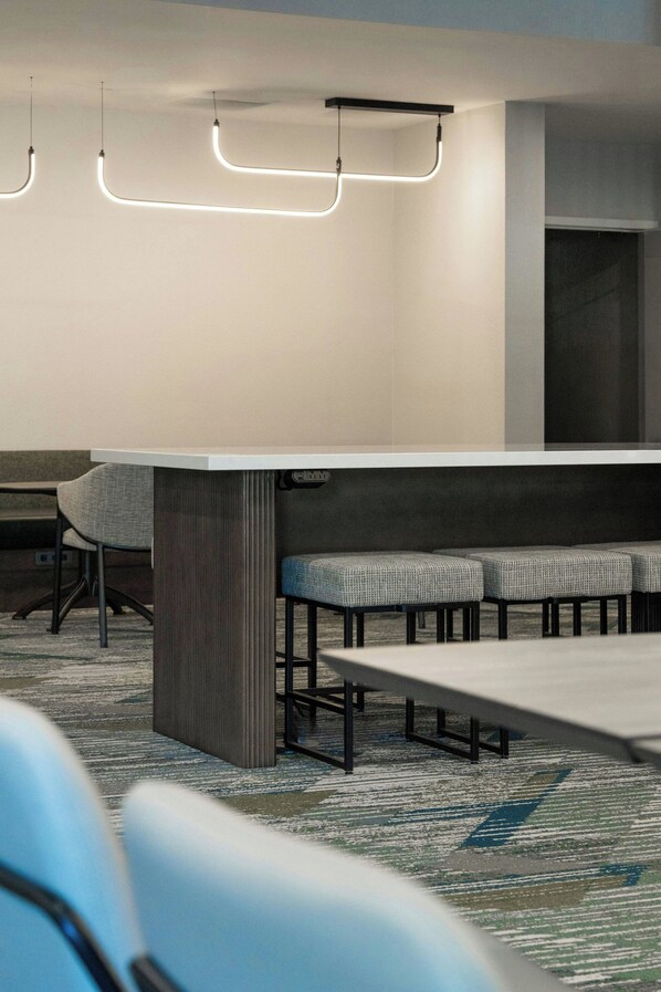 A conference room with a long table, several chairs, and pendant lighting.