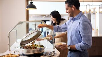 A buffet setup with various food items and utensils.