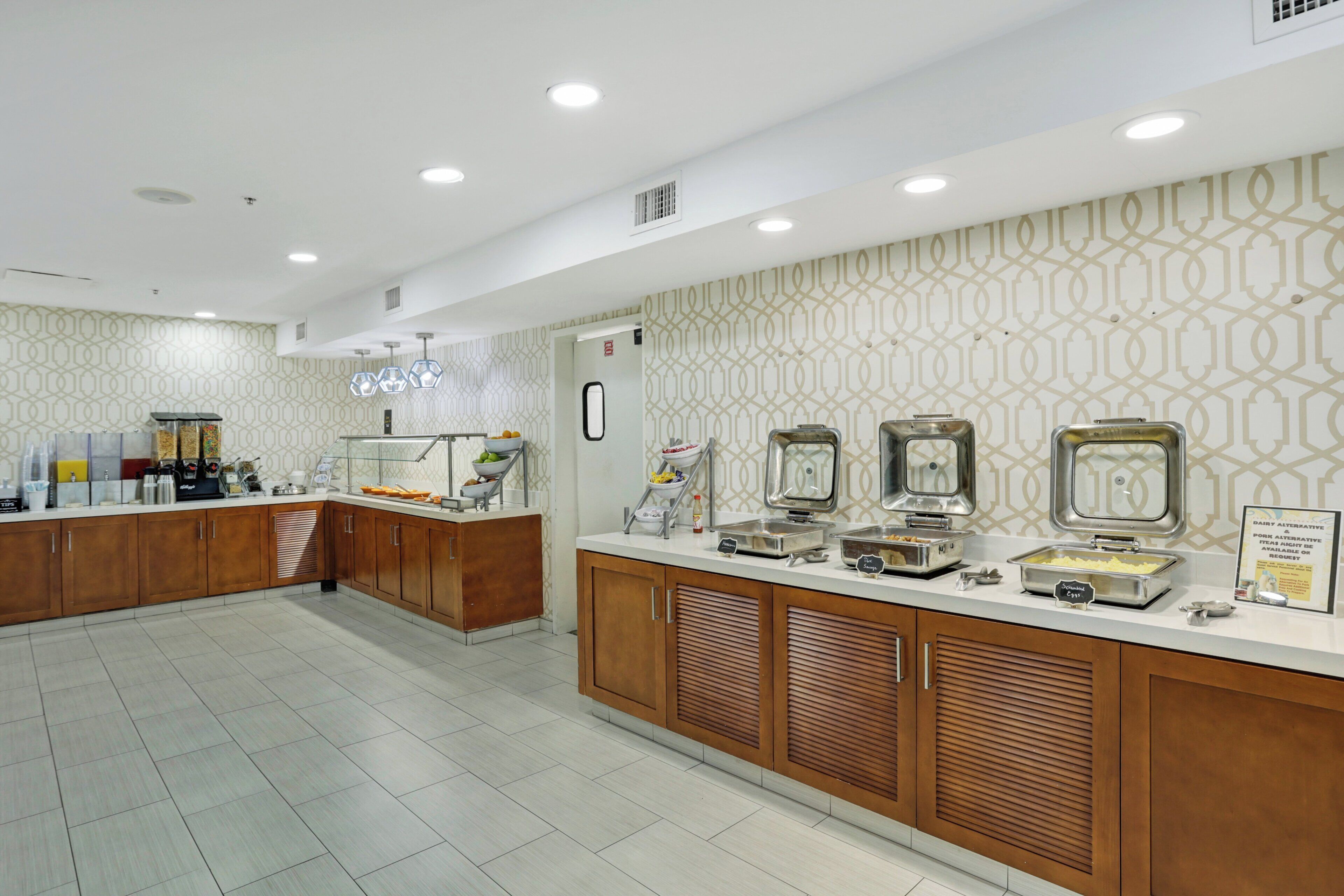 Un espace buffet comprenant un comptoir, des présentoirs pour les plats et un mur décoré de motifs.