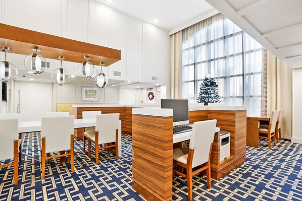 A modern hotel lobby with a reception desk, seating area, and large windows. - Staybridge Suites Columbia Baltimore by IHG (Columbia)