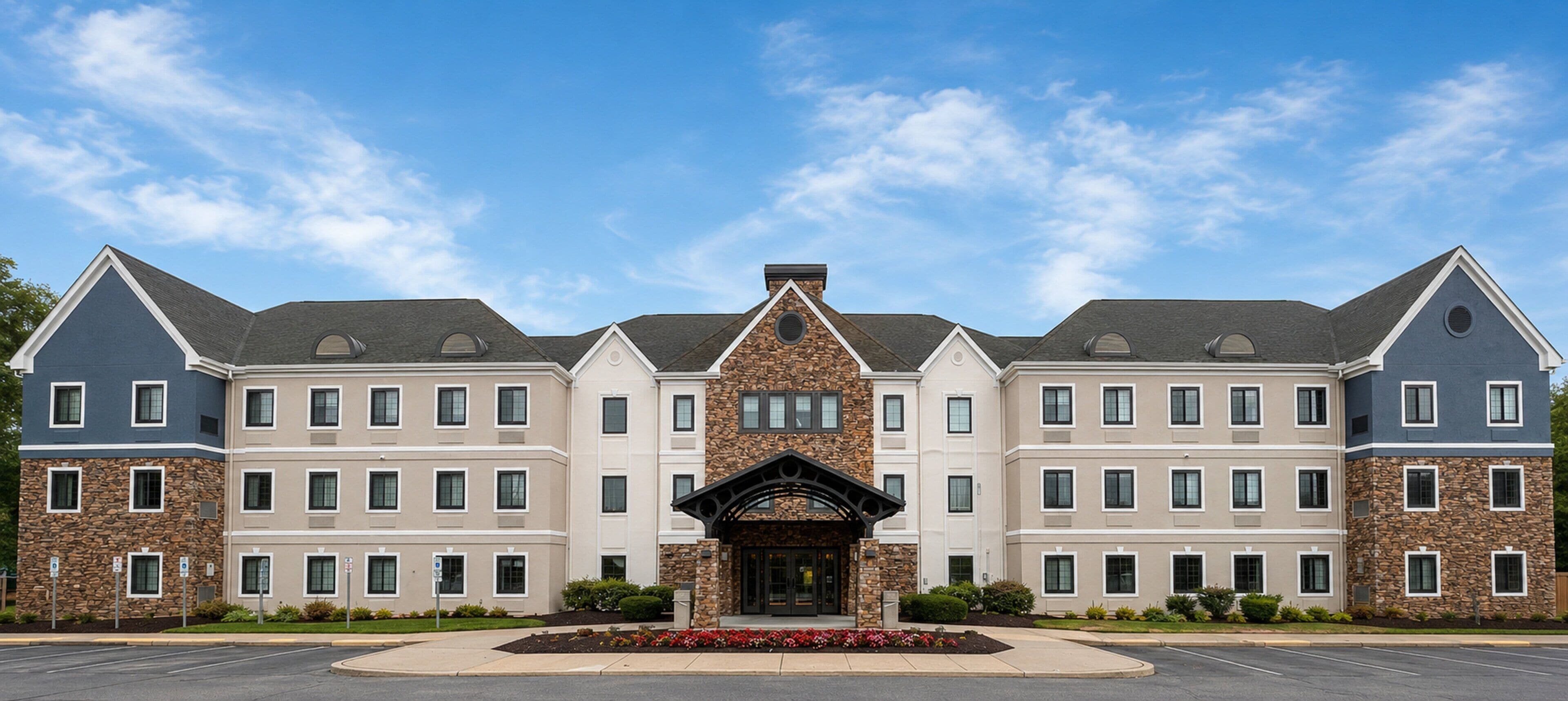 A multi-story hotel with a central entrance, stone facade, and uniform window design.