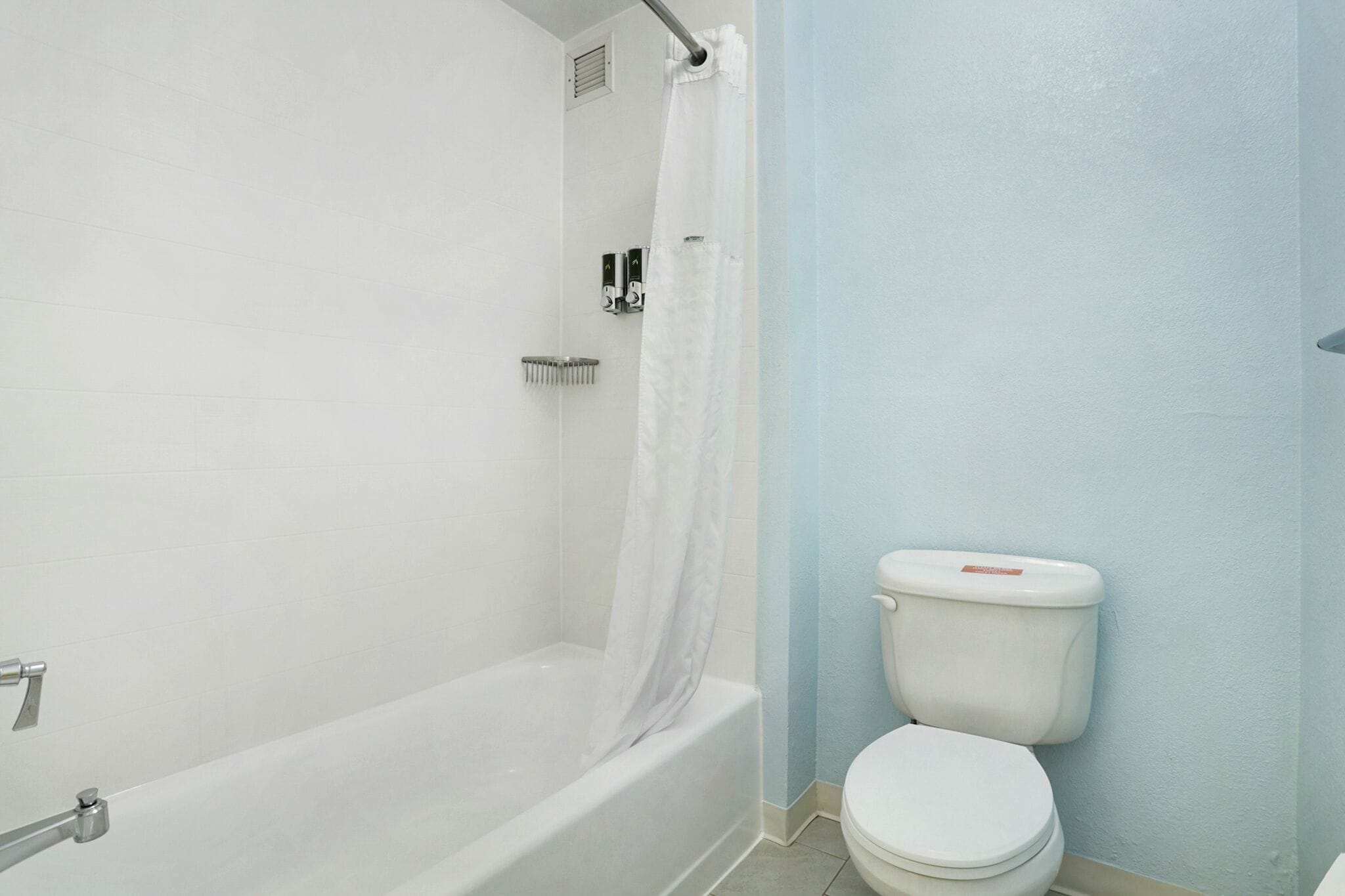 Un baño con bañera, inodoro y cortina de ducha.