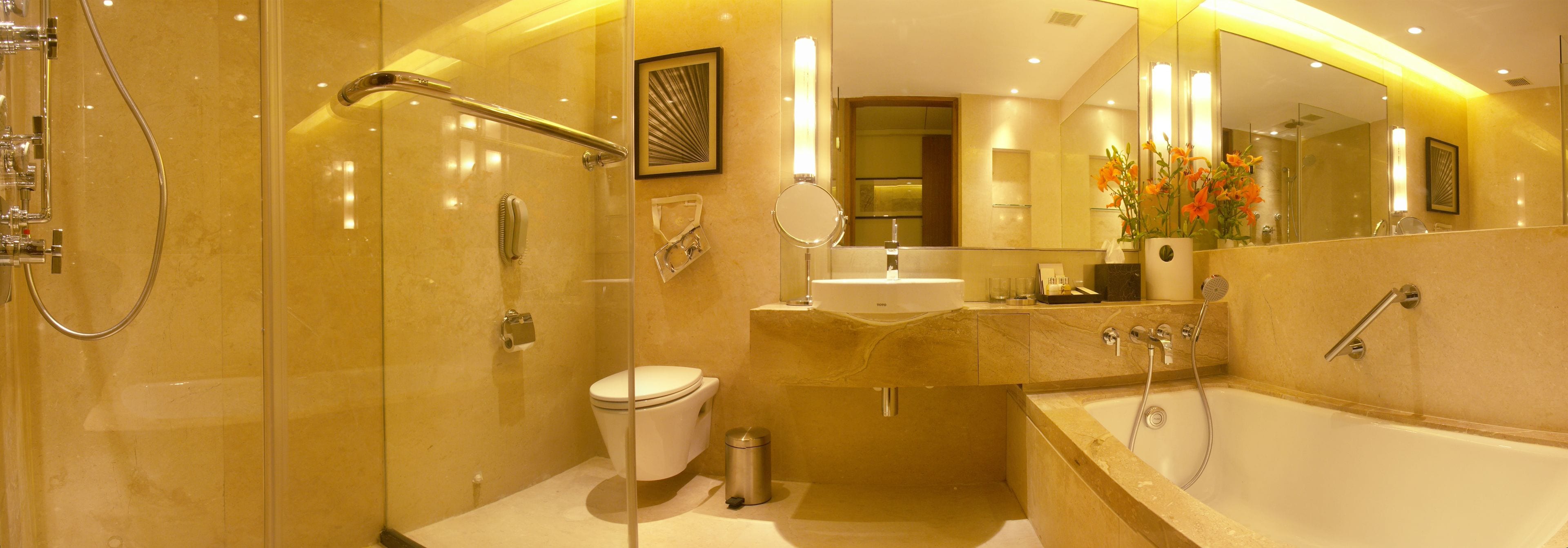 Un baño moderno con ducha acristalada, inodoro, lavamanos y bañera.