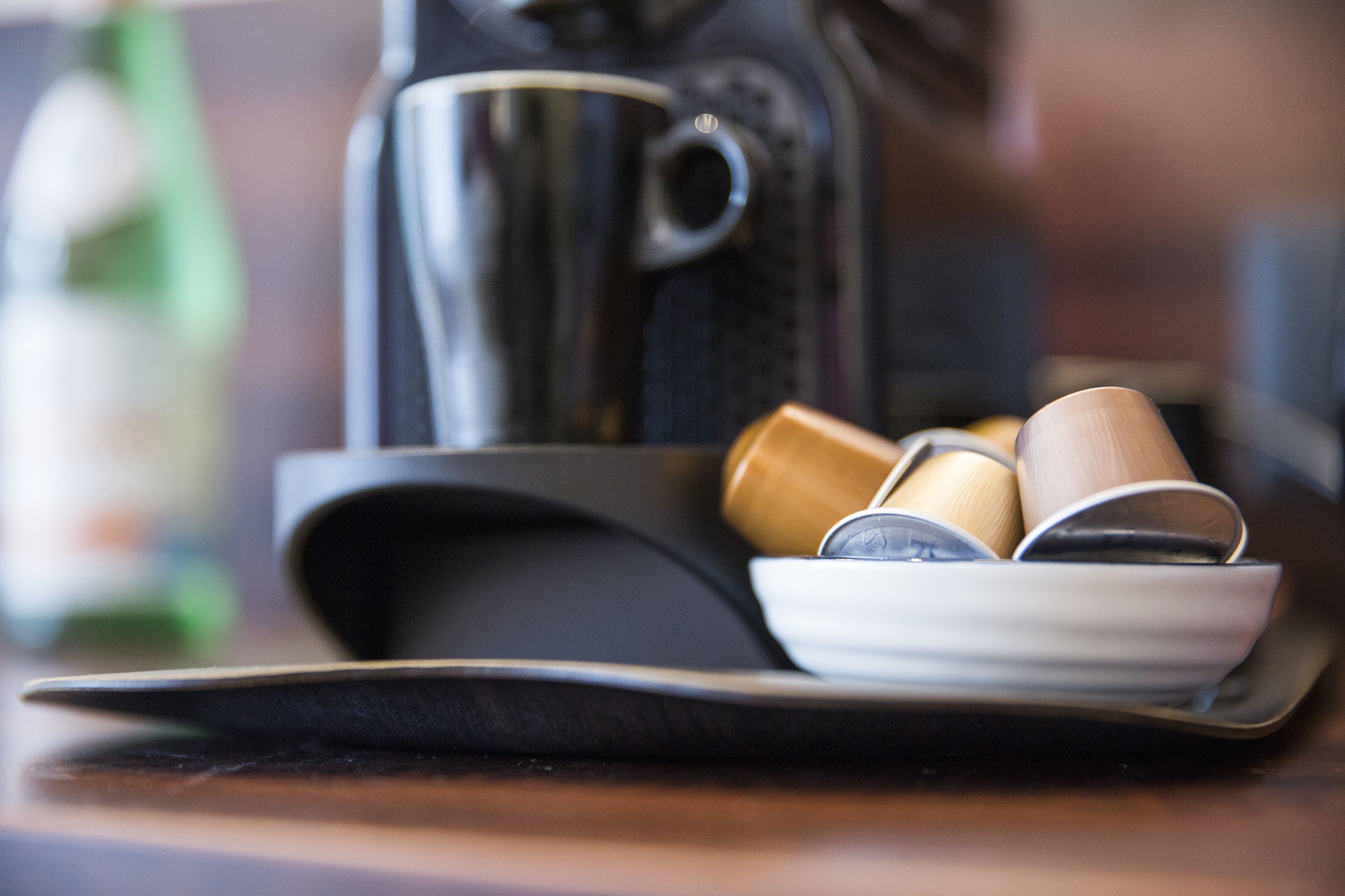 Ein Tablett mit einer Kaffeemaschine und Tassen auf einem Tisch.