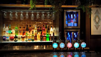 A bar area with a variety of liquor bottles and a selection of beer taps.