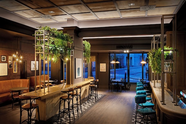 Een bar met houten toog, krukken en uitzicht op de straat.