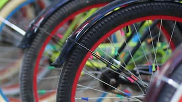 A close-up of bicycle wheels with colorful spokes and tires.