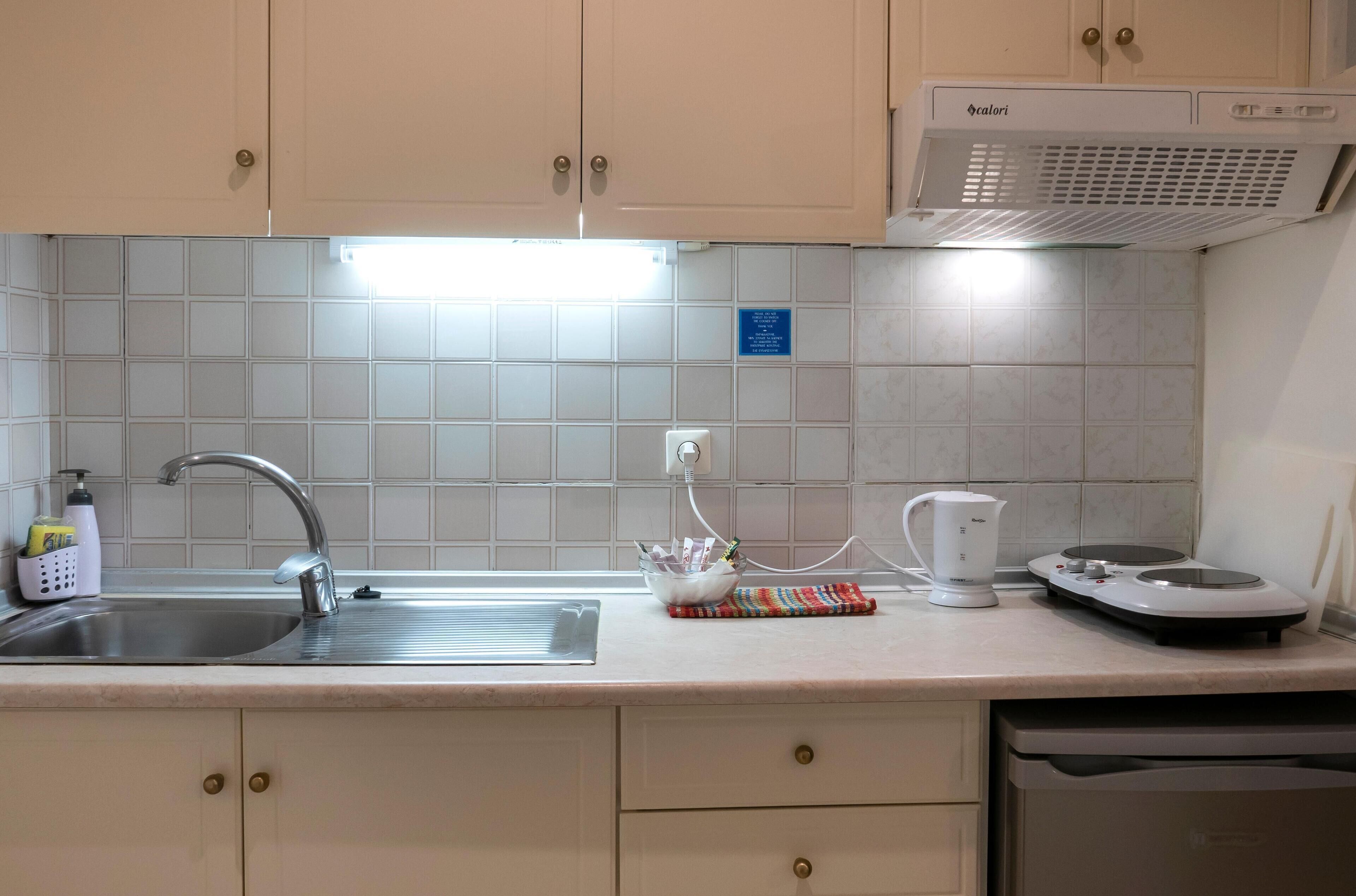A kitchen with a sink, a coffee maker, and a modern stove.