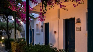 A building with a white facade, dark doors, and a small mailbox. - Villea Village by GHH (Sitia)