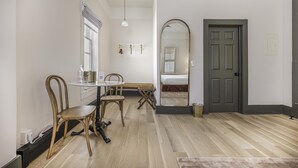 Une pièce comprenant une table à manger, des chaises, un miroir et une porte.