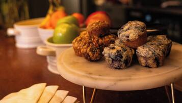 A dessert platter with muffins and fruits on a table.