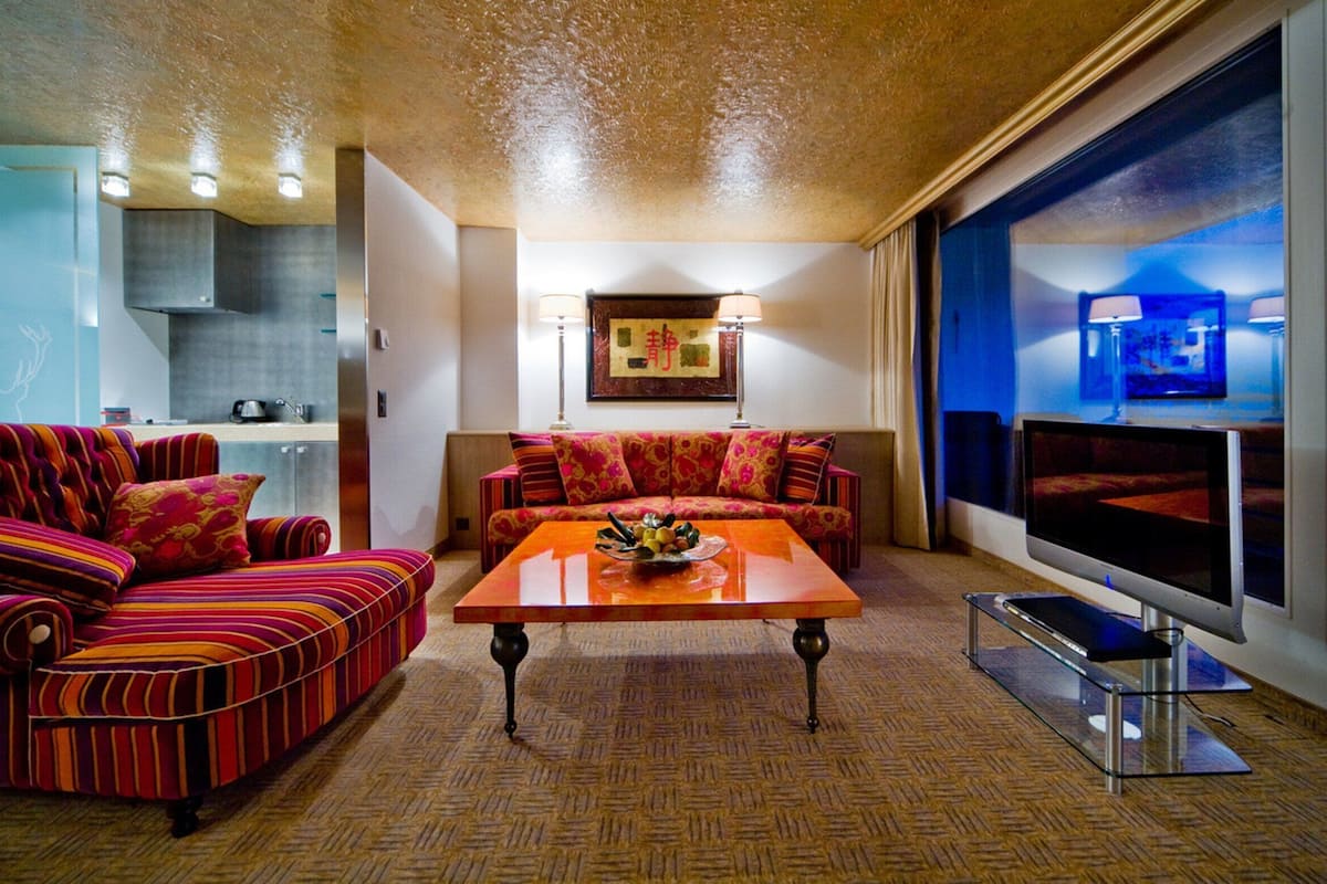 A modern living room with a sofa, a coffee table, and a television.