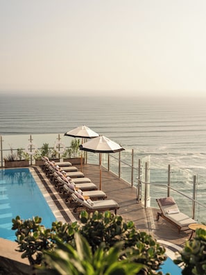 A poolside area with lounge chairs and umbrellas overlooking the ocean. - Miraflores Park, A Belmond Hotel, Lima (Lima)