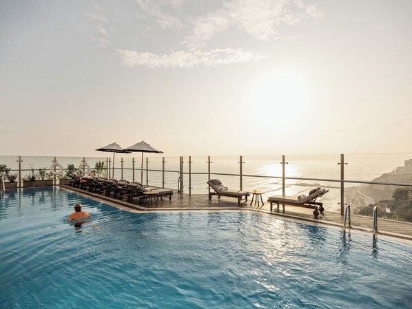 Outdoor pool, open 6:00 AM to 10:00 PM, pool umbrellas