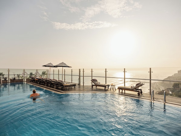 Outdoor pool, open 6:00 AM to 10:00 PM, pool umbrellas