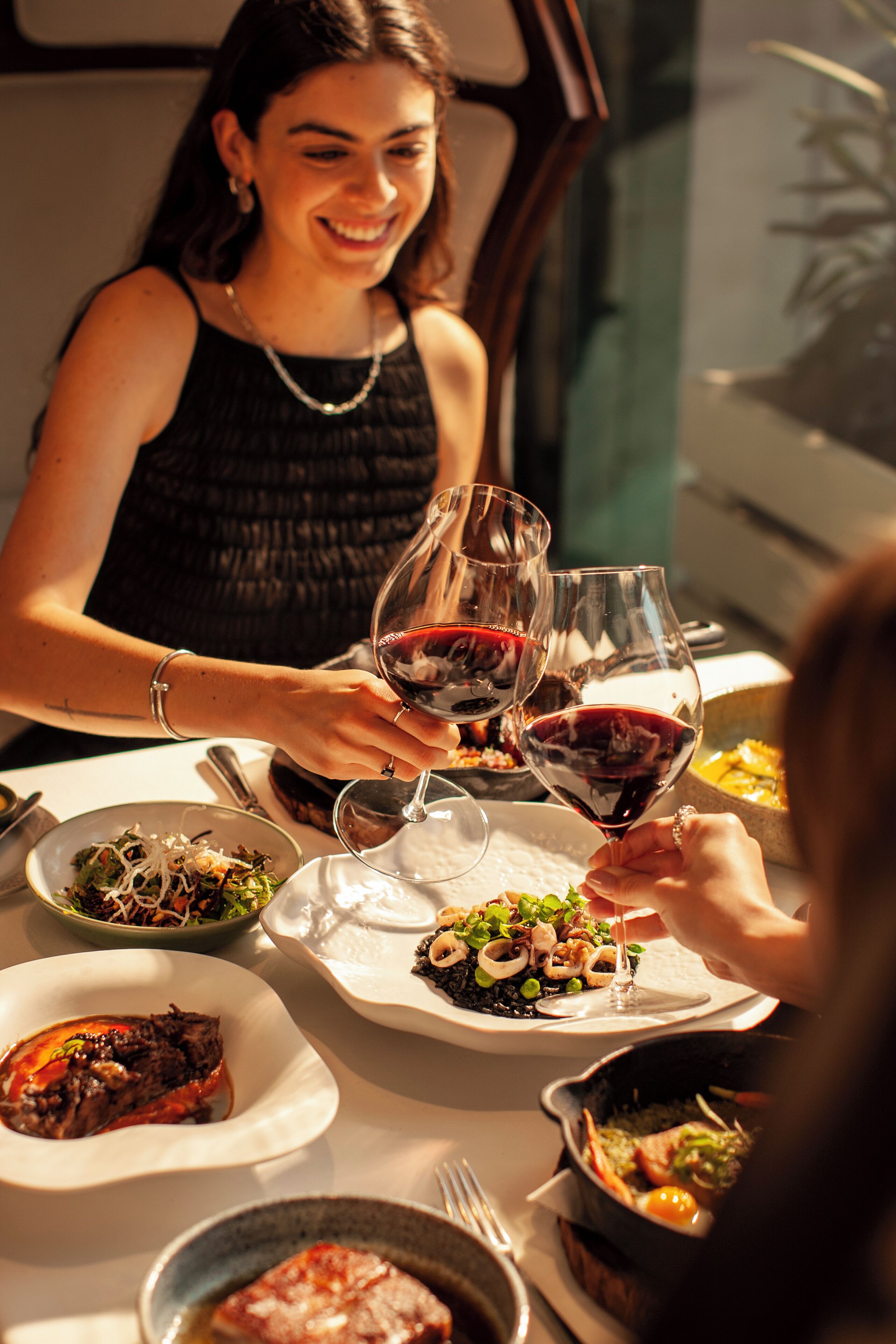 A dining table with various dishes and wine glasses.
