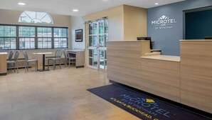 A reception area with a desk, chairs, and a large window. - Microtel Inn & Suites by Wyndham Atlanta/Buckhead Area (Atlanta)