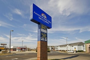 A sign for an America Best Value Inn & Suites with a clear sky in the background. - Americas Best Value Inn And Suites Mcdonough (McDonough)
