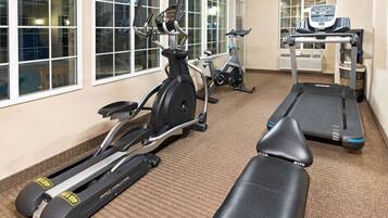 A gym with treadmills, stationary bikes, and a rowing machine.