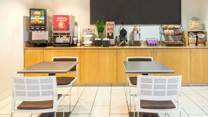 A café with a counter, vending machines, and seating. - Microtel Inn & Suites by Wyndham Pueblo (Pueblo)