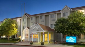 A Microtel hotel with a two-story structure, a covered front porch, and a sign indicating it is a motel. - Microtel Inn & Suites by Wyndham Pueblo (Pueblo)